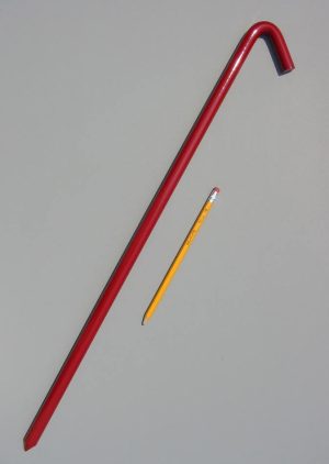 24 inch metal hook style tent stake in red and a pencil for scale